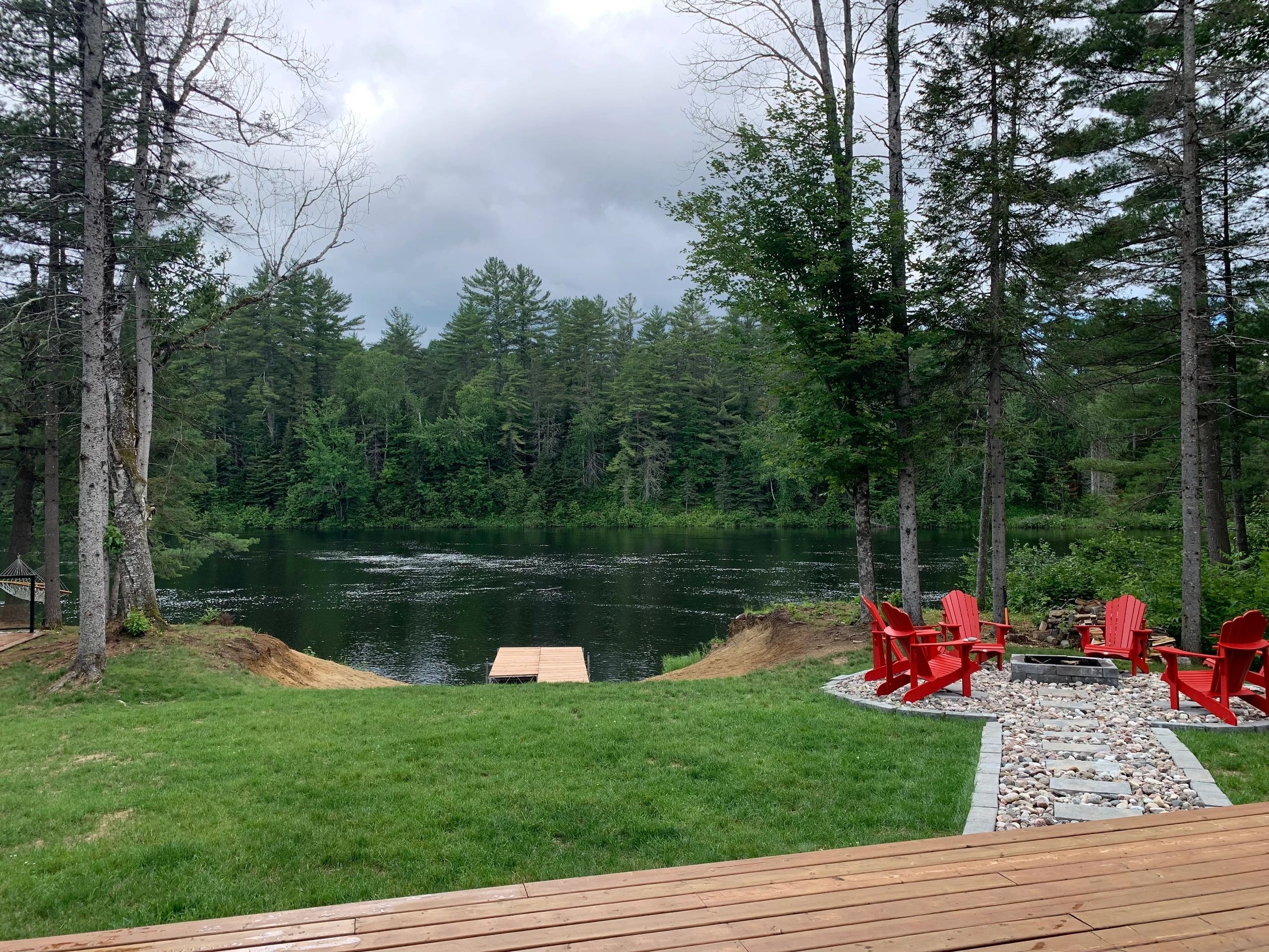 Serene lakefront with dock and red chairs